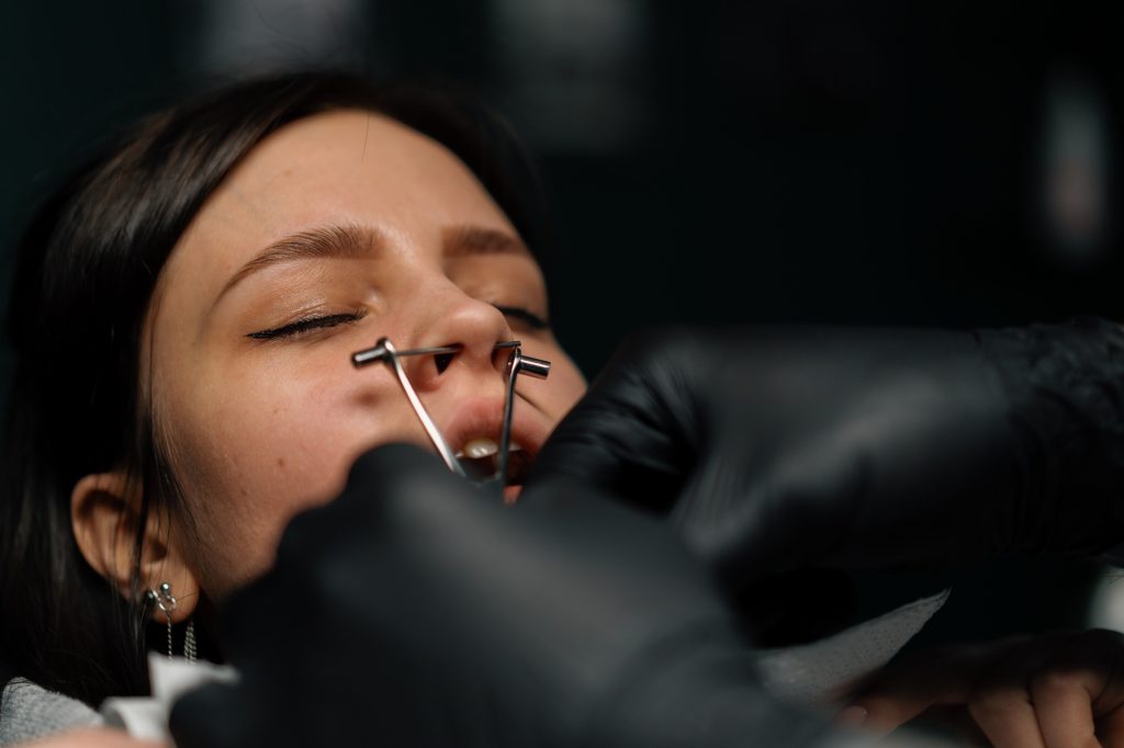 Piercing studio. a master pierces a girl's nose