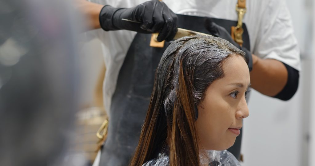 Woman undergo hair color dye and wait for the treatment in beauty salon