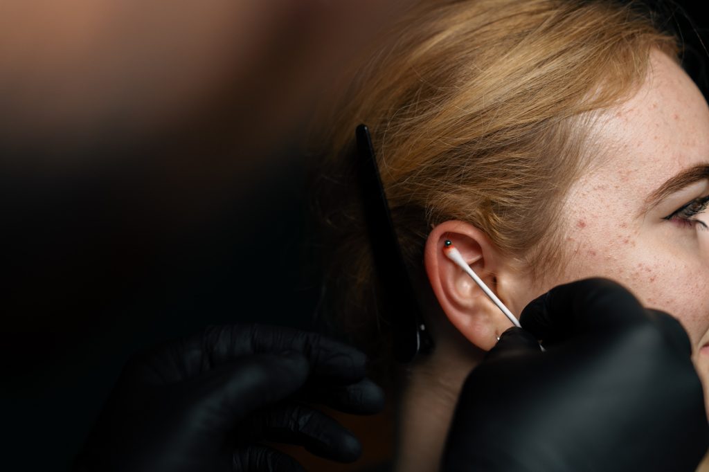 Piercing studio. a master pierces a girl's ear